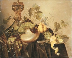 Still life with Akelei covered beaker, an upturned berkeyer resting on a nautilus shell, grapes, lemon and a knife by Pieter Nason